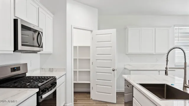 a kitchen with white cabinets and appliances