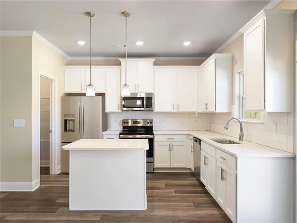 a kitchen with stainless steel appliances a white refrigerator a sink and a stove