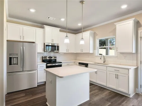 a kitchen with a sink stainless steel appliances and window