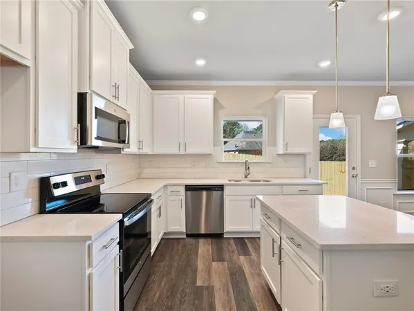a kitchen with a sink stove top oven and cabinets