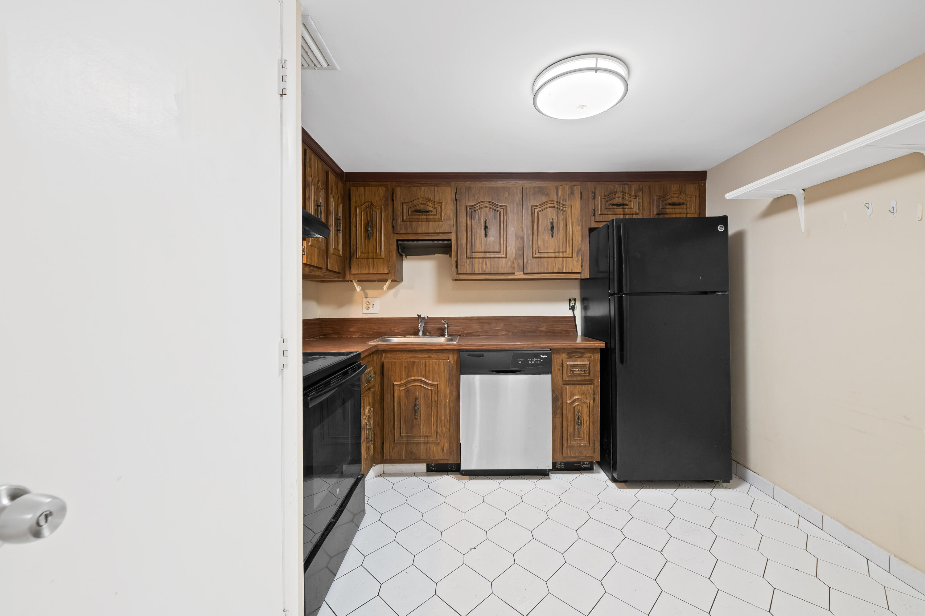 4156 Inverrary Drive, Unit 210 Lauderhill, FL 33319 - Photo 22 of 27 a kitchen with a refrigerator and a sink
