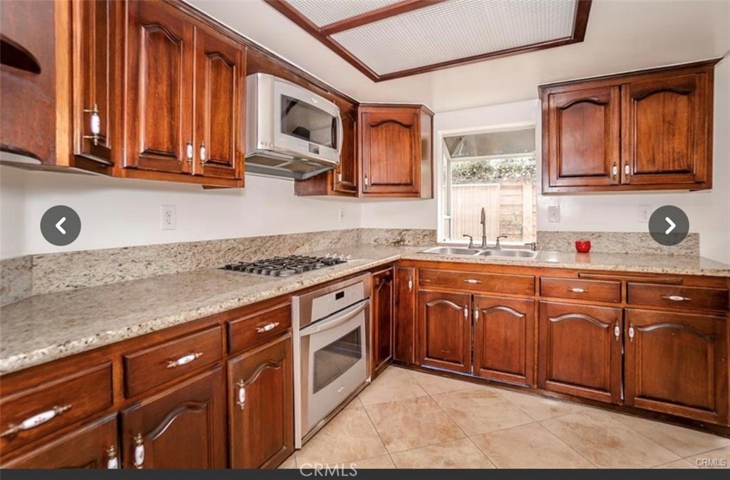 9846 California South Gate, CA 90280 - Photo 3 of 9 a kitchen with stainless steel appliances granite countertop a sink stove and cabinets