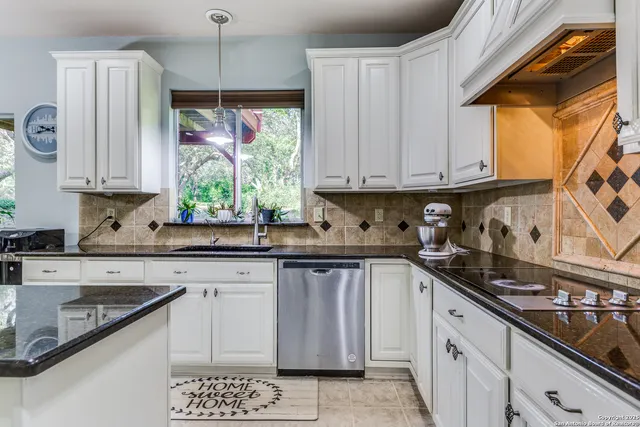 a kitchen with stainless steel appliances granite countertop a sink a stove and a microwave