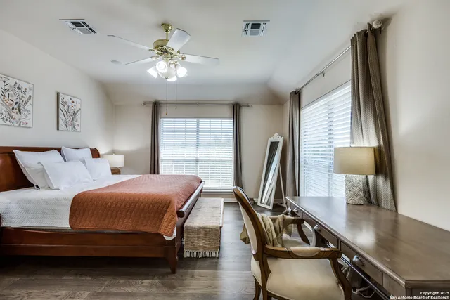 a bedroom with bed and a flat tv screen on dresser