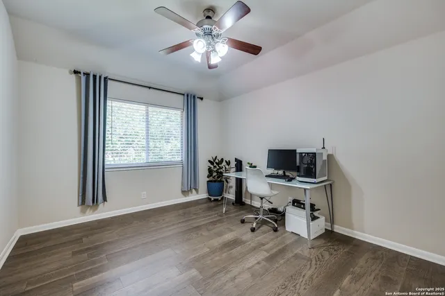 a view of a workspace with furniture and a window