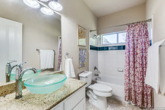 a bathroom with a granite countertop sink a toilet and a mirror