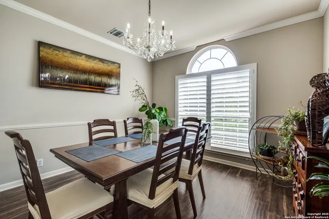 a dining room with furniture potted plants and wooden floor