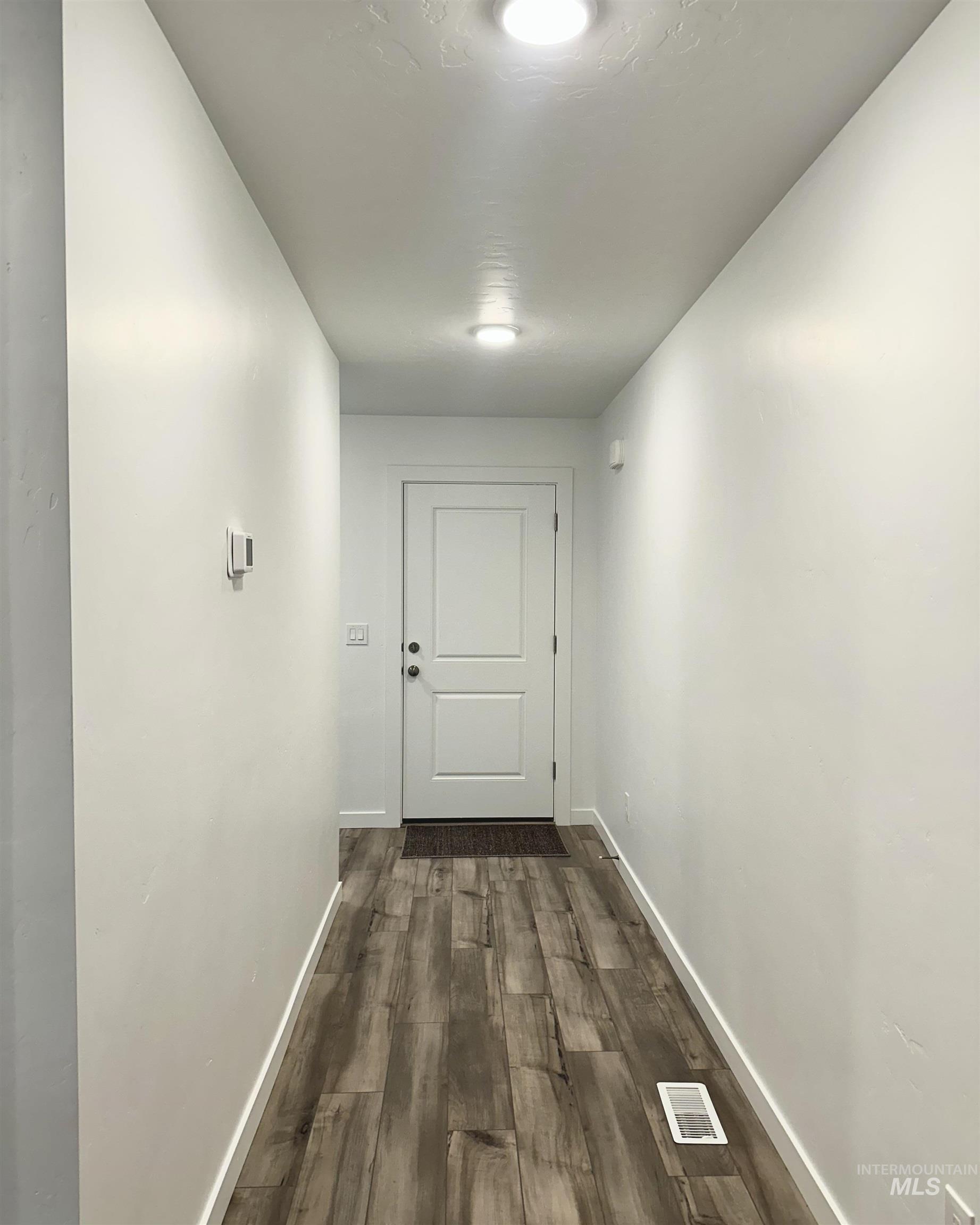 15402 Nimbus Way Caldwell, ID 83607 - Photo 2 of 9 Corridor featuring baseboards and dark wood finished floors