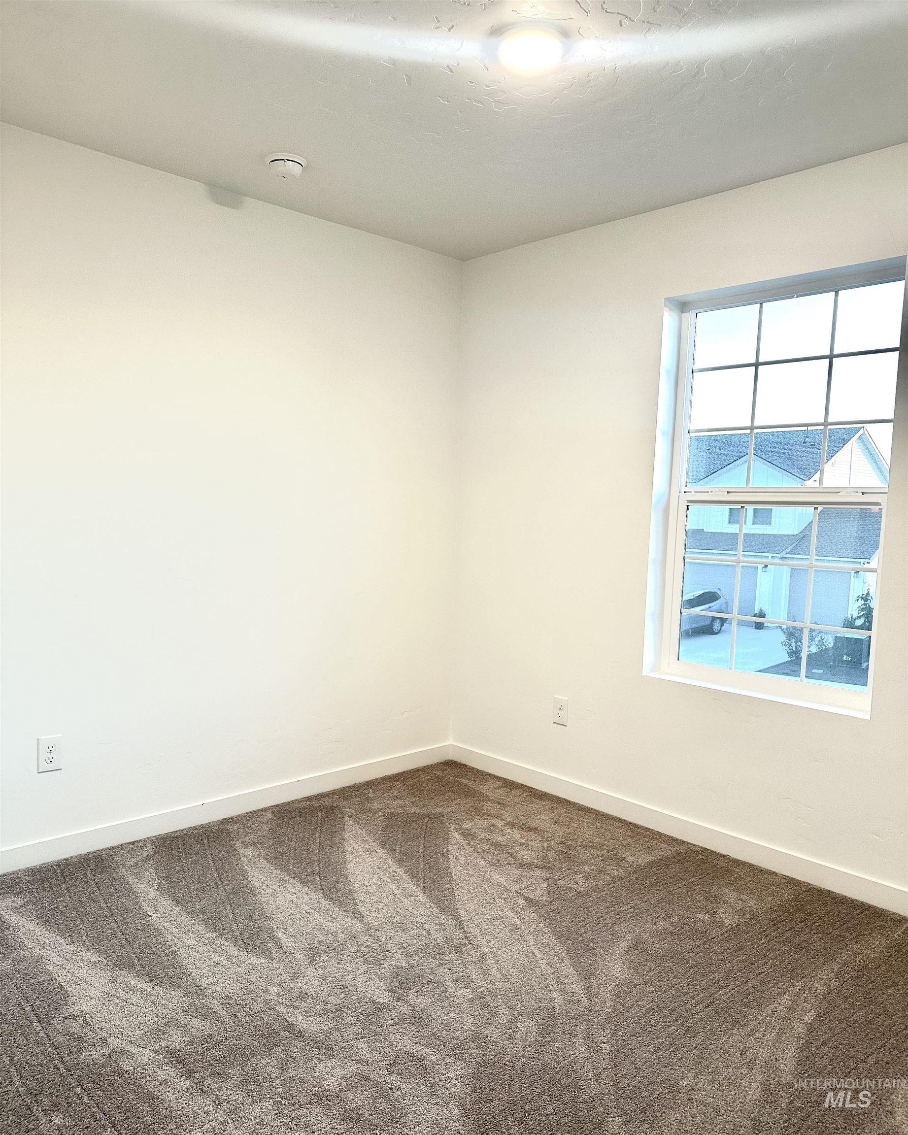 15402 Nimbus Way Caldwell, ID 83607 - Photo 6 of 9 Unfurnished room featuring baseboards and dark carpet