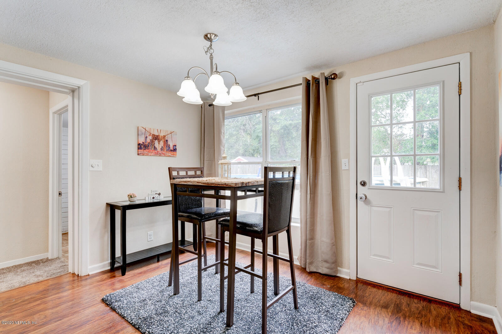 6245 Suwanee Road Jacksonville, FL 32217 - Photo 10 of 27 a dining room with wooden floor a chandelier a wooden table and chairs