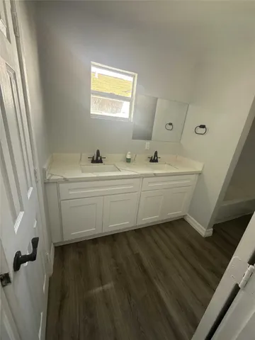 a bathroom with a double vanity sink a mirror and a bathtub