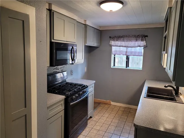 a kitchen with sink a microwave a stove and refrigerator