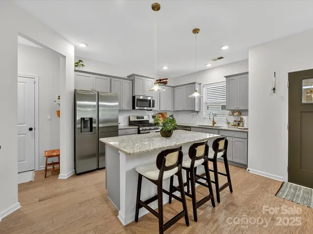 a kitchen with kitchen island a refrigerator a counter space and appliances
