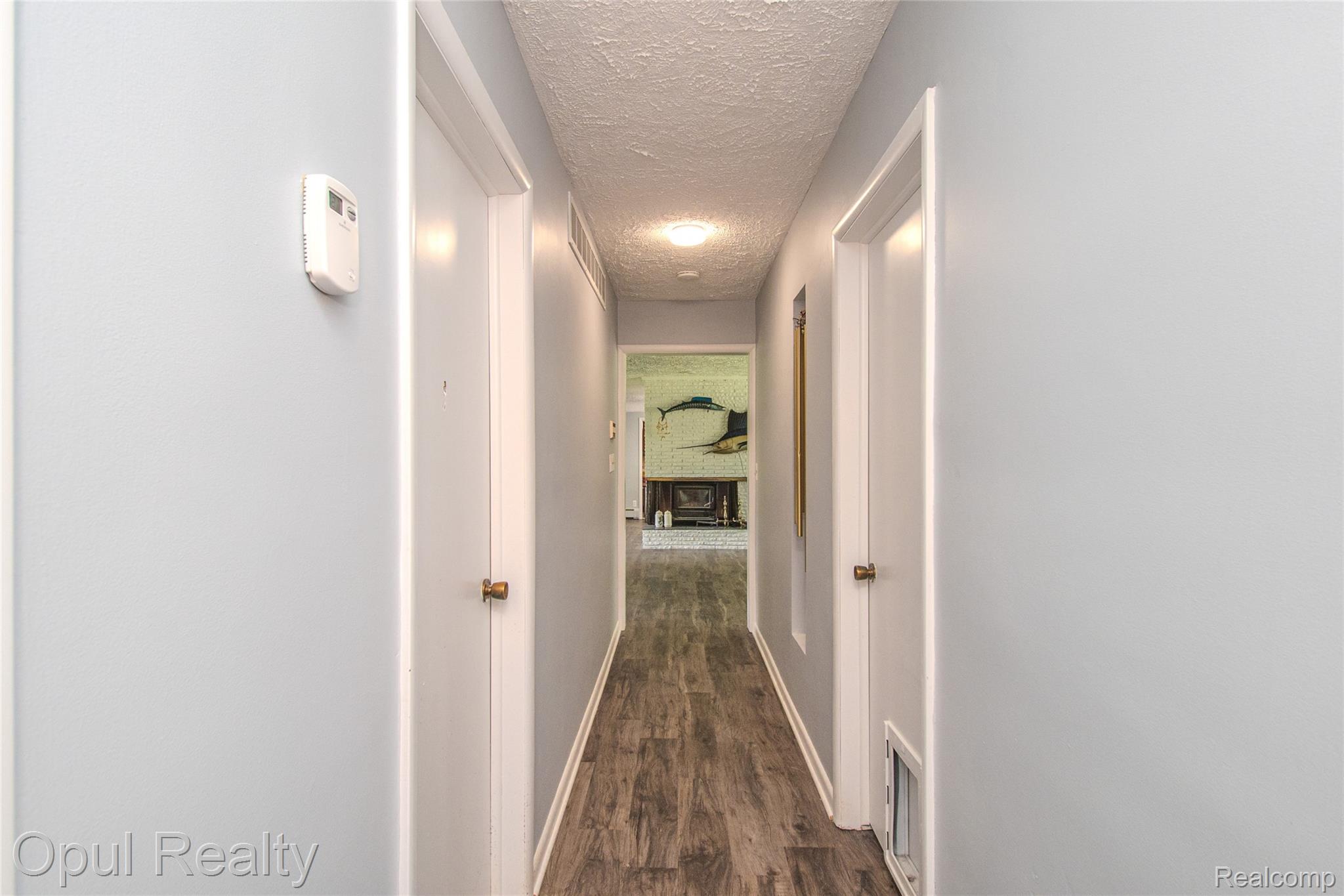 6455 Norham Road Bloomfield Hills, MI 48301 - Photo 48 of 93 Hallway featuring wood-finish flooring, light blue walls, white trim, and recessed lighting