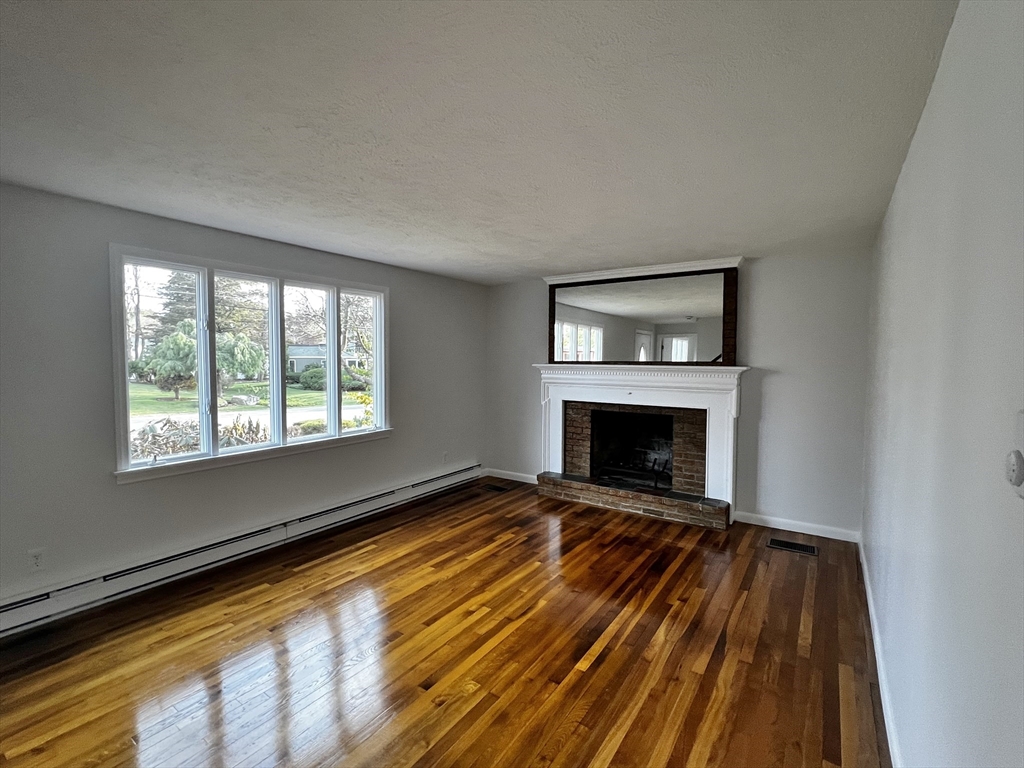 6 Mayfield Road Auburn, MA 01501 - Photo 18 of 30 a view of an empty room with a fireplace and a window