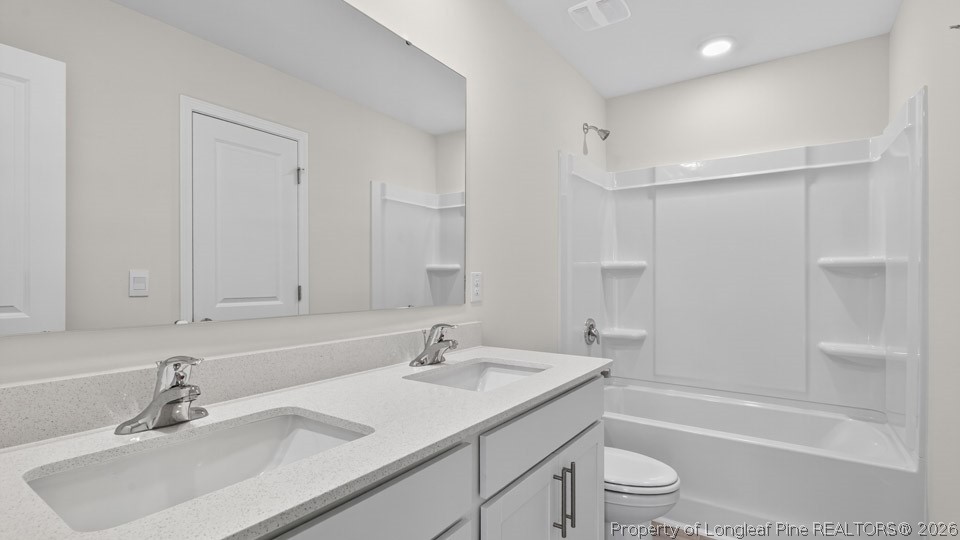 123 Charlies Bnd Way Spring Lake, NC 28390 - Photo 28 of 34 a bathroom with a sink double vanity granite tub shower and a toilet