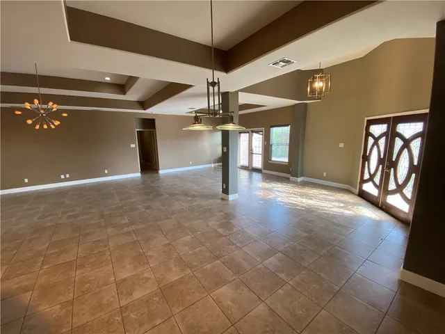 a view of a hall with stairs and a chandelier