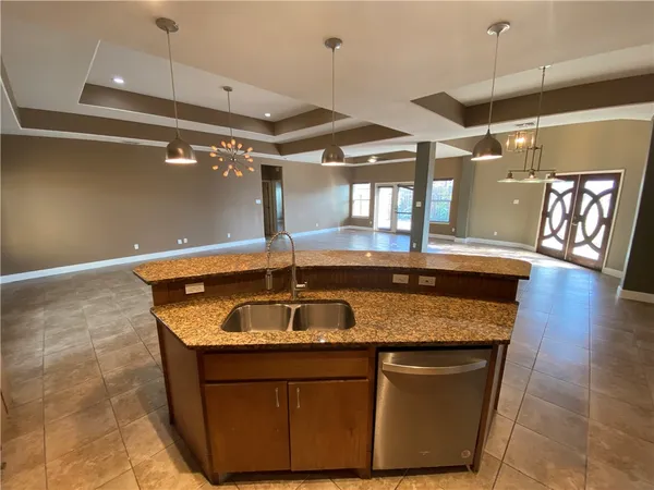 a kitchen with granite countertop a sink and wooden floor