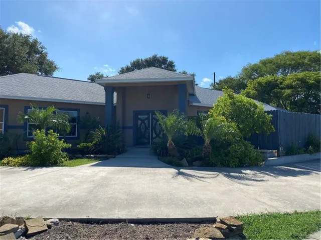 a view of a house with a small yard and plants