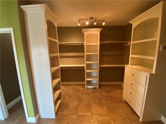 a view of walk in closet with empty racks