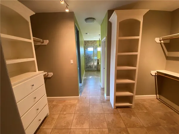 a view of walk in closet with empty racks