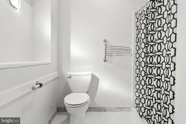 a white toilet sitting next to a shower curtain