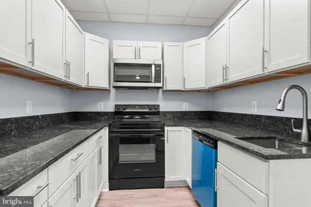 a kitchen with stainless steel appliances granite countertop a sink stove and cabinets