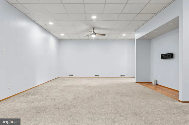 an empty room with a ceiling fan and window