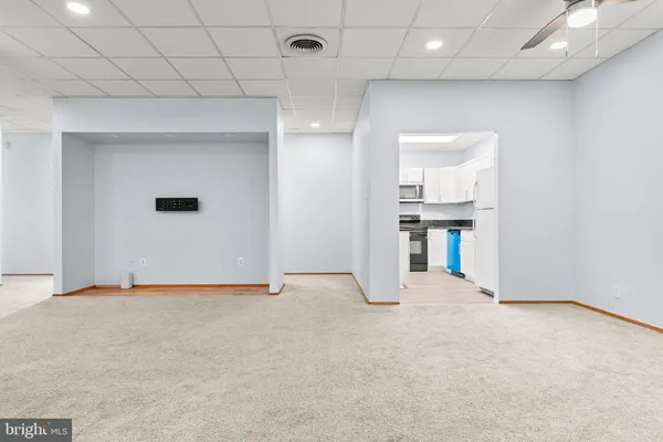 an empty room with kitchen and fireplace