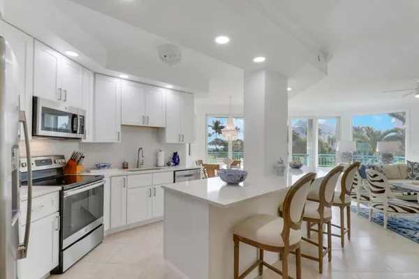 a kitchen with stainless steel appliances a stove a sink a microwave a refrigerator and cabinets