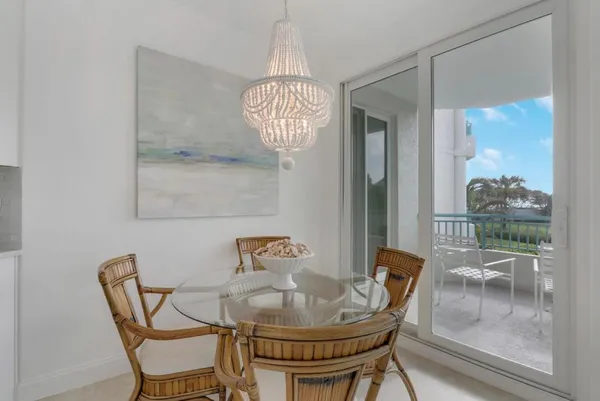 a dining room with furniture a chandelier and wooden floor