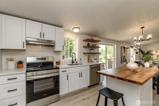 a kitchen with granite countertop a stove cabinets and wooden floor