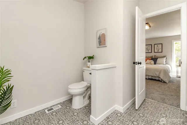 a bathroom with a toilet and a shower