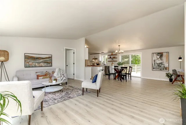 a living room with furniture and a dining table with kitchen view