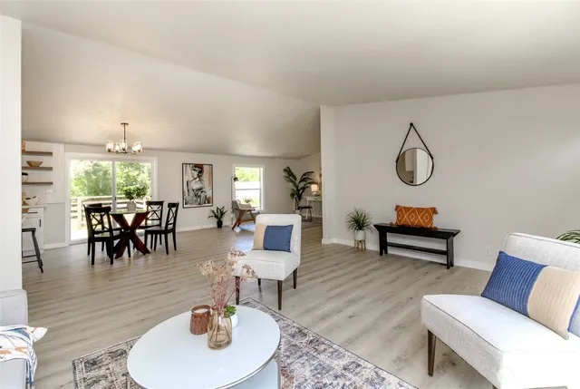 a living room with furniture and a dining table with kitchen view