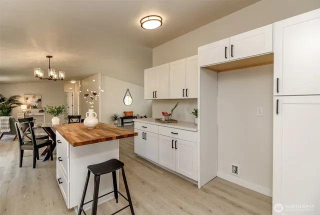 a kitchen with granite countertop kitchen island stainless steel appliances a stove a sink a refrigerator and a dining table with wooden floor