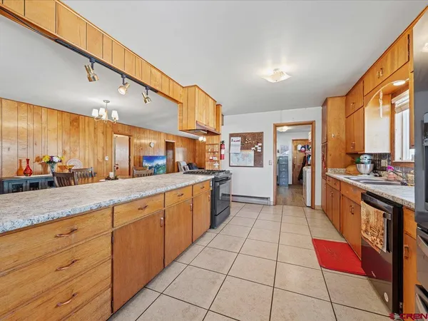 a large kitchen with stainless steel appliances kitchen island granite countertop a large counter top and a stove