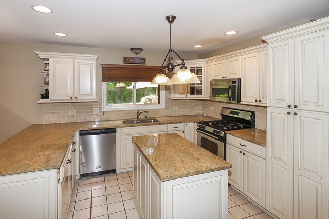 650 Raintree Court Buffalo Grove, IL 60089 - Photo 8 of 25 a kitchen with stainless steel appliances granite countertop a stove a sink and a refrigerator