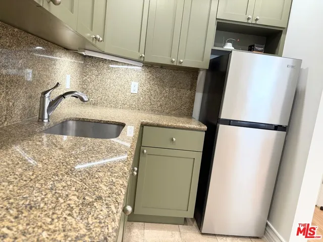 a kitchen with granite countertop white cabinets and sink