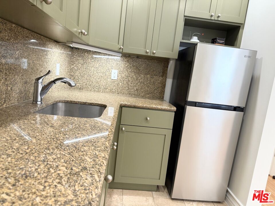 204 South Reeves Drive Beverly Hills, CA 90212 - Photo 8 of 10 a kitchen with a refrigerator and a sink