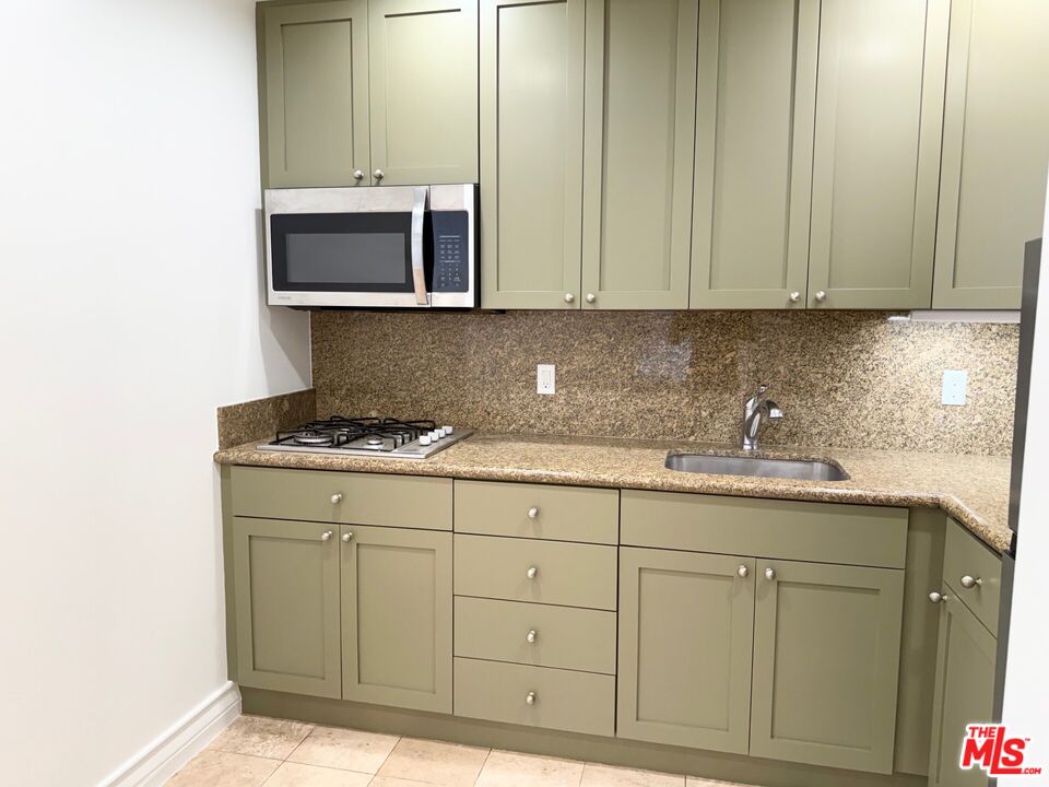 204 South Reeves Drive Beverly Hills, CA 90212 - Photo 9 of 10 a kitchen with granite countertop white cabinets and sink