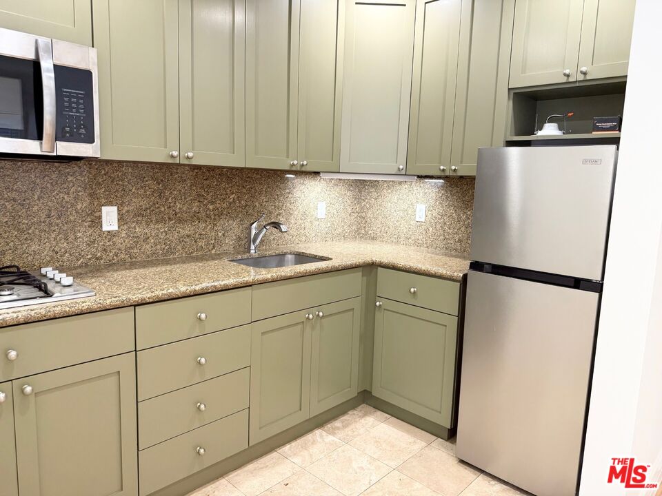 204 South Reeves Drive Beverly Hills, CA 90212 - Photo 10 of 10 a kitchen with stainless steel appliances white cabinets and a refrigerator