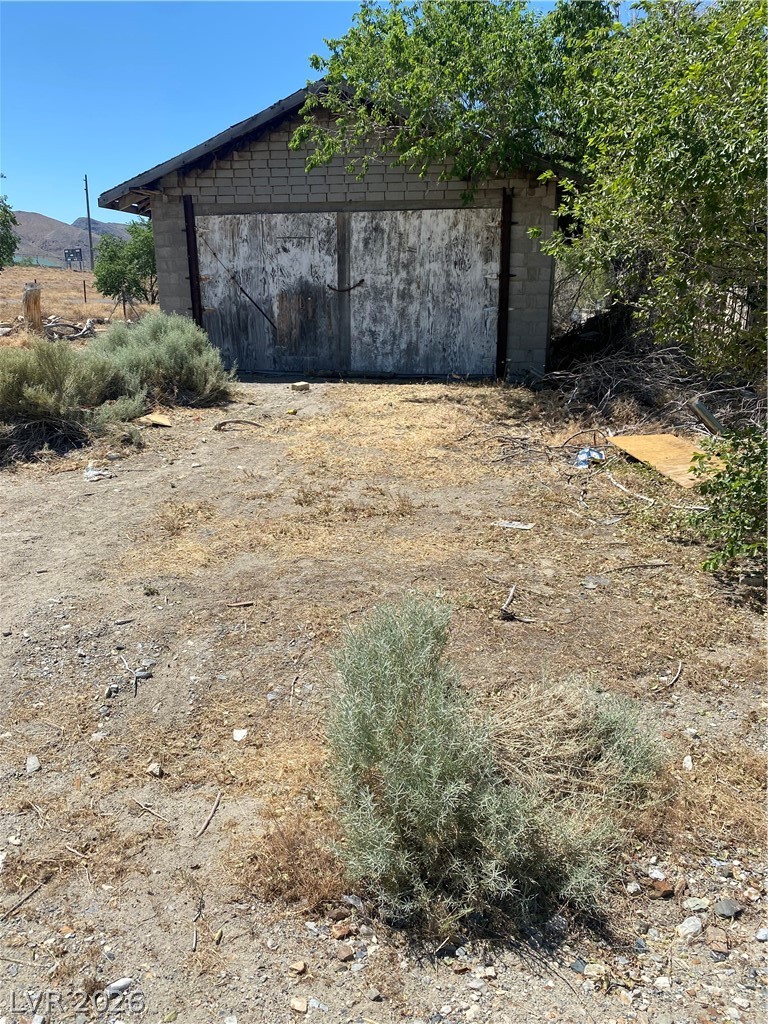 701 3rd Street Gabbs, NV 89409 - Photo 5 of 10 A sturdy storage building with double doors stands amidst natural arid landscaping.
