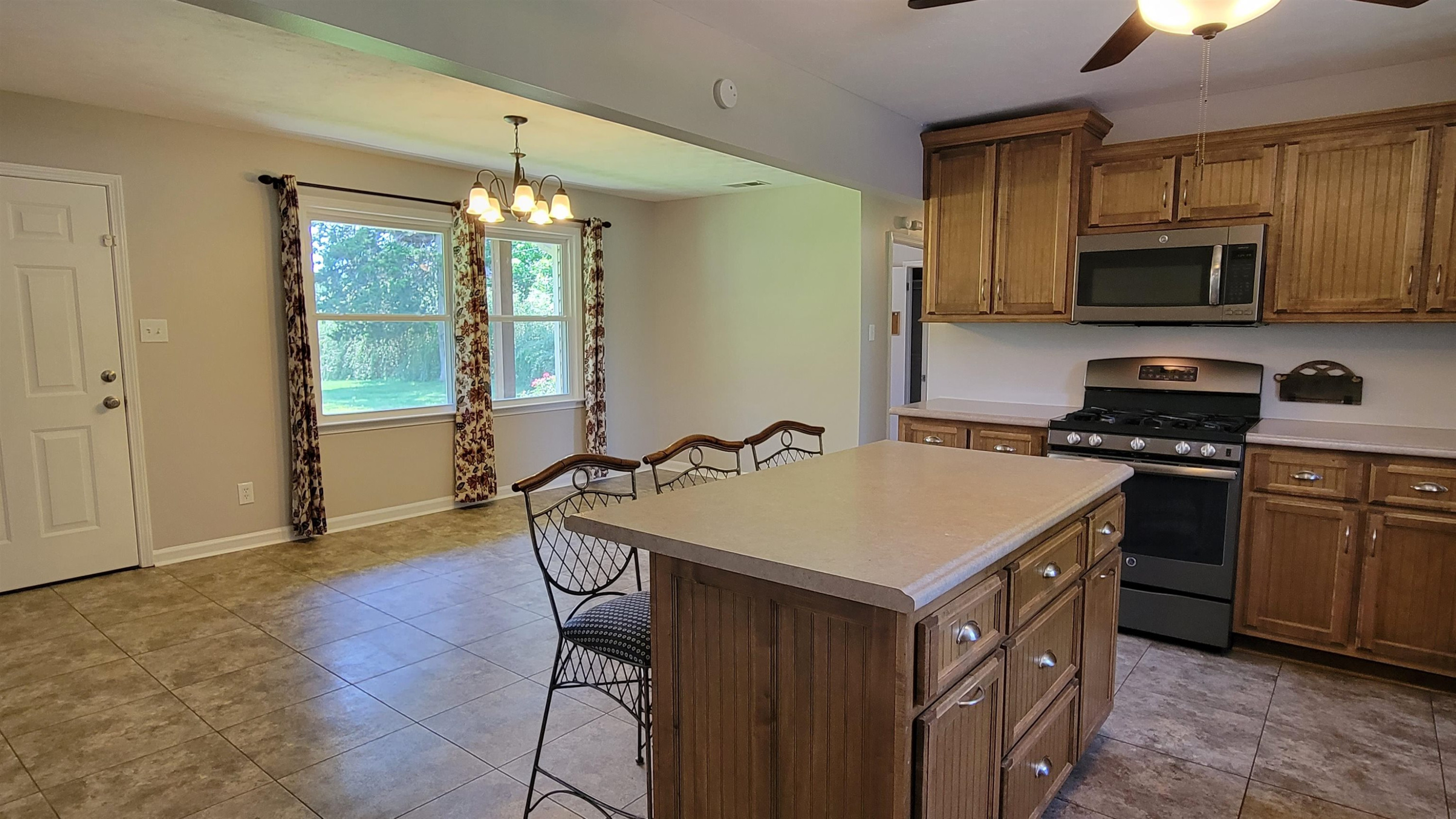 183 Spring Creek Law Road Jackson, TN 38305 - Photo 11 of 42 a kitchen with stainless steel appliances a sink a stove a refrigerator cabinets and a dining table
