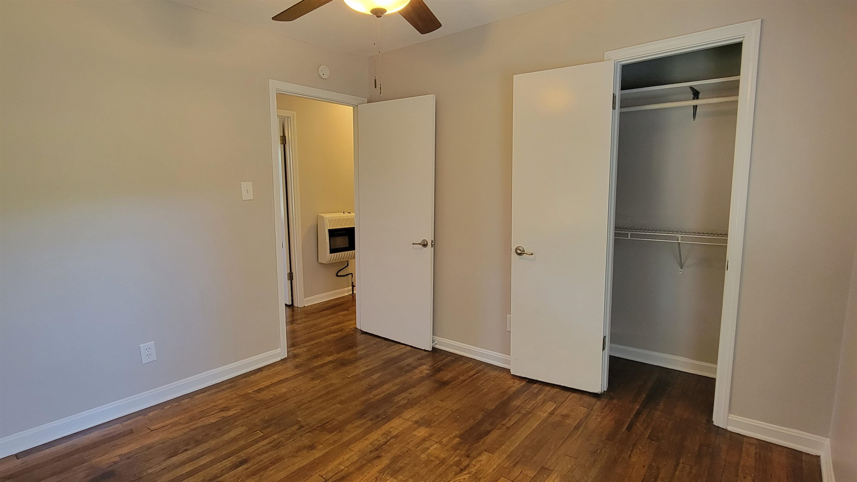 183 Spring Creek Law Road Jackson, TN 38305 - Photo 23 of 42 an empty room with wooden floor and a ceiling fan