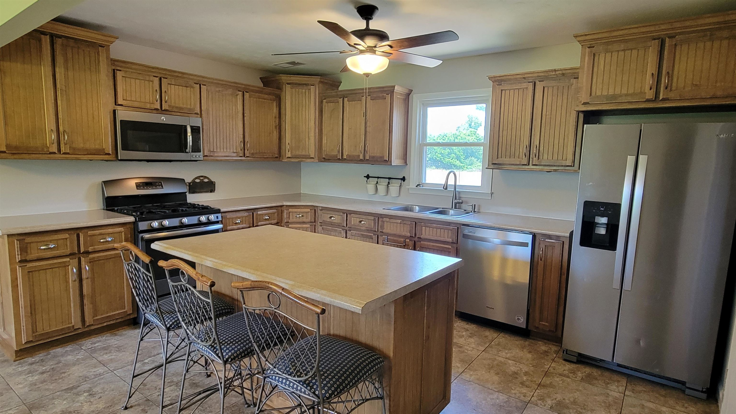 183 Spring Creek Law Road Jackson, TN 38305 - Photo 5 of 42 a kitchen with stainless steel appliances granite countertop a sink a stove a refrigerator cabinets and a dining table