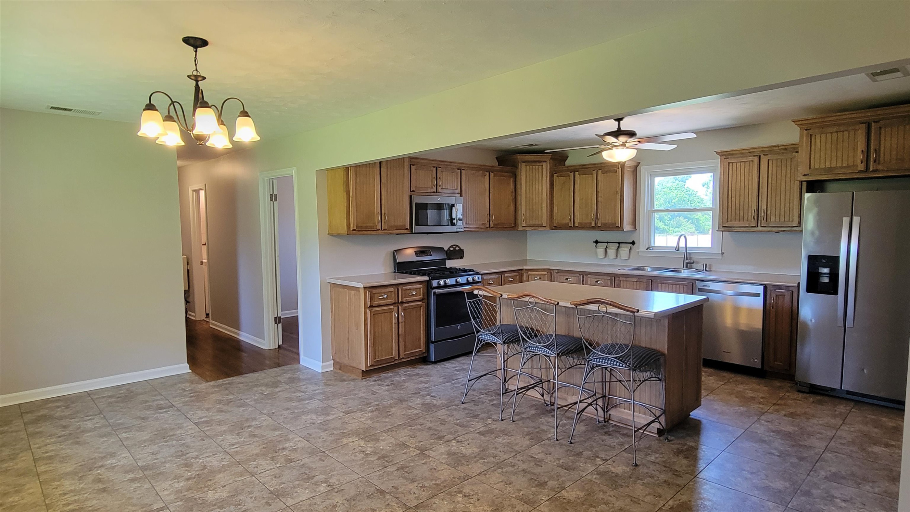 183 Spring Creek Law Road Jackson, TN 38305 - Photo 6 of 42 a kitchen with kitchen island granite countertop stainless steel appliances a stove refrigerator a sink and dishwasher