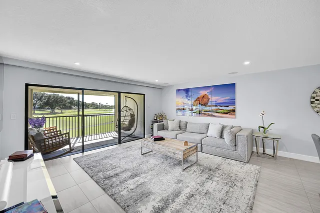 a living room with furniture large windows and a flat screen tv