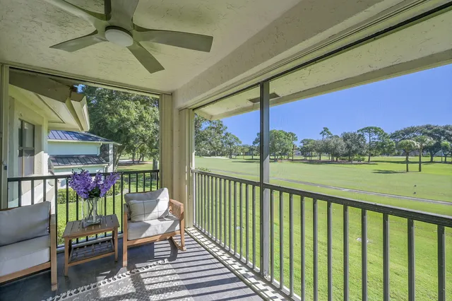 a view of a chairs and table in patio next to a yard