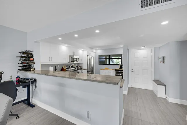 a kitchen with stainless steel appliances granite countertop a refrigerator and a stove top oven